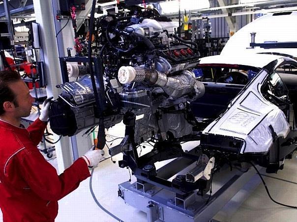 Motormontage in der Karosserie (Hochzeit). Uwe Geiger beim Verbau des Motors in die Karosse. Mit Hilfe des Hebekrans setzt er den Motor in der dafür gedrehten R8-Karosse ab.